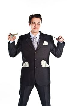 Portrait of a young businessman in a dark suit surrounded by flying dollar bills