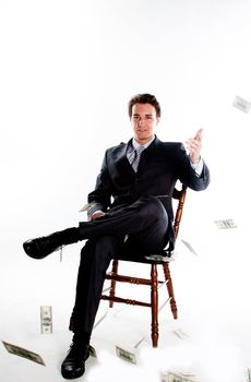 Portrait of a young businessman in a dark suit surrounded by flying dollar bills