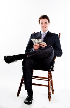 Portrait of a young businessman in a dark suit surrounded by flying dollar bills