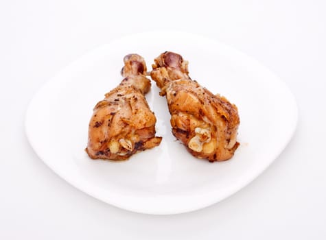 two crispy fried chicken legs on a white dish