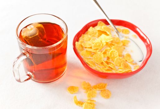 cornflakes in bowl and tea cup on table