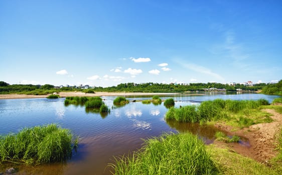 calm river under blue sky at summer day