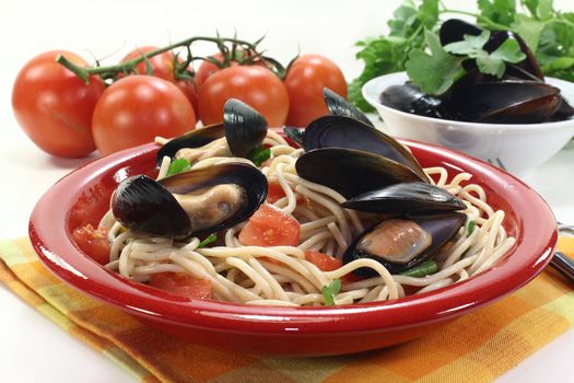 a plate of spaghetti, mussels and tomato