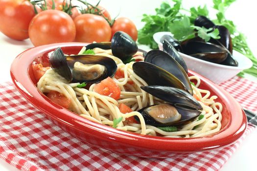 a plate of spaghetti, mussels and tomato