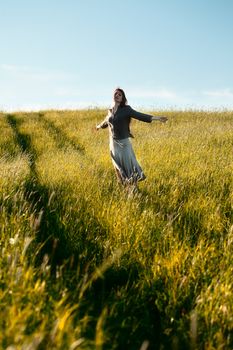 happy woman with open arms in field at summer day