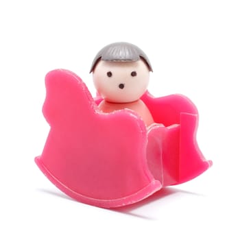 toy baby sitting in rocking chair, isolated on white