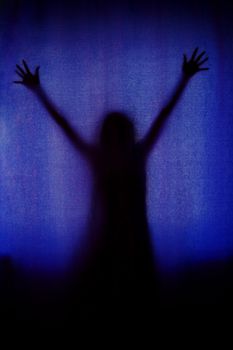 ghost woman black silhouette behind blue curtain