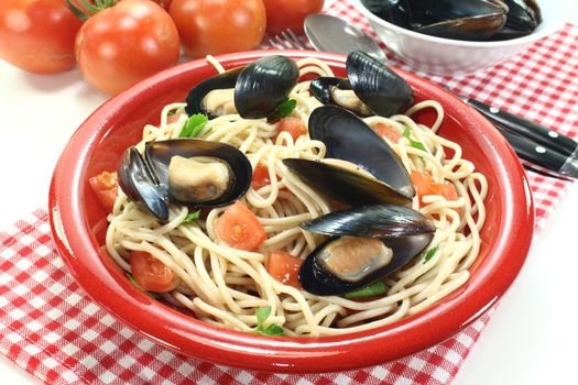 a plate of spaghetti, mussels and tomato