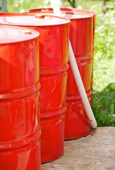 three old red metal barrels in yard
