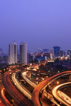 City skyline with multiple flyovers with busy traffic light trails