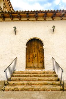 A wooden colonial door on the side of an old church