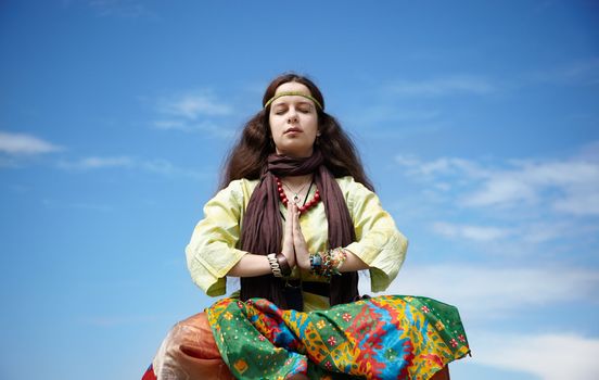 young woman with long hair on blue sky background