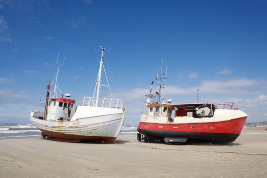 Worn boats on the beach towards blue sky