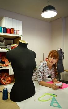 woman in sewing studio with mannequin and items