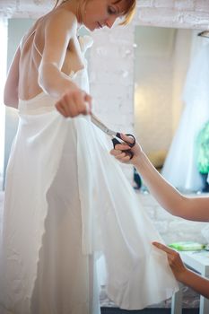 beautiful woman in white wedding dress in sewing studio