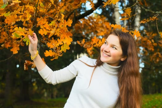 beautiful smiling girl in autumn oak forest