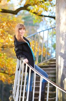 beautiful girl on tower stairway in autumn park