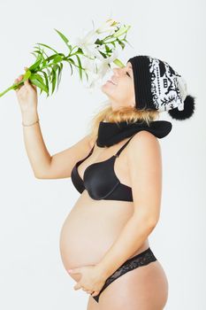 happy young pregnant woman with white lily