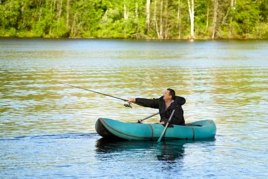 man fishing in rubber boat on a lake