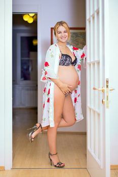 happy smiling pregnant woman standing in room