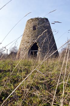 Ancient abandoned windmill built of stones fragment. Retro vintage architecture nostalgia.