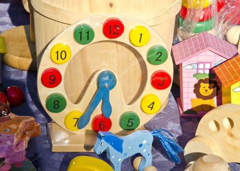 Playgrounds wooden colorful toys. Clock imitation horses houses.