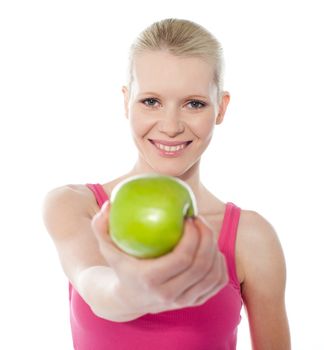 Teenager offering green apple, full of vitamins isolated on white