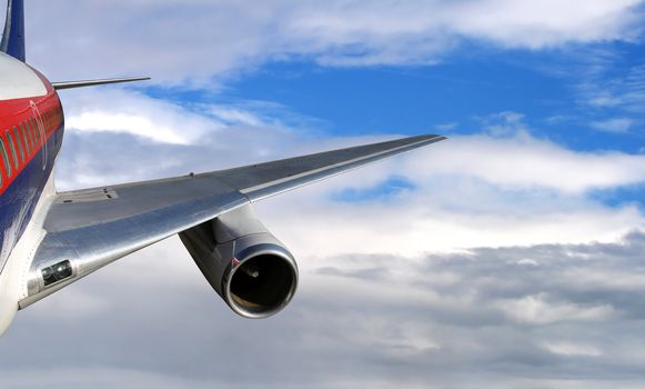 Aerial shot of an airplane flying in high cloudy sky