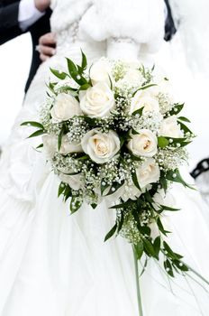 Bridal bouquet of flowers in the hands of newlyweds