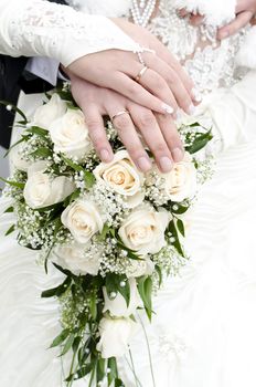 Bridal bouquet of flowers with hands of newlyweds