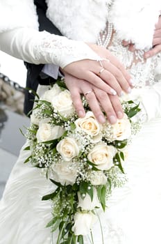 Bridal bouquet of flowers with hands of newlyweds