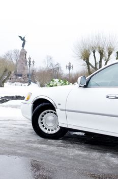 Part of white limousine, wedding car with flowers.