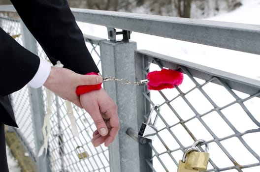 Man hands with red handcuffs. 