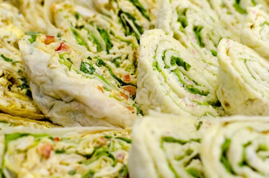 Pita bread. Rolls stuffed with greens and ham. Closeup.