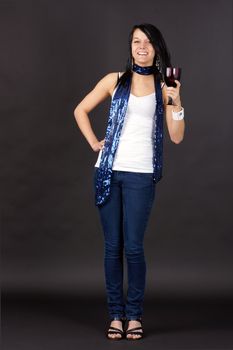 Complete body shot of a pretty young woman partying,  holding purple glass and toasting.