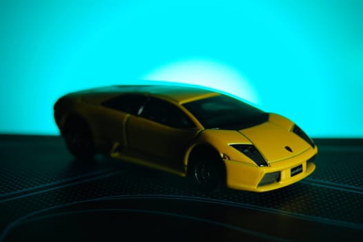 Scale model replica of lamborghini murciélago on blue sunburst background