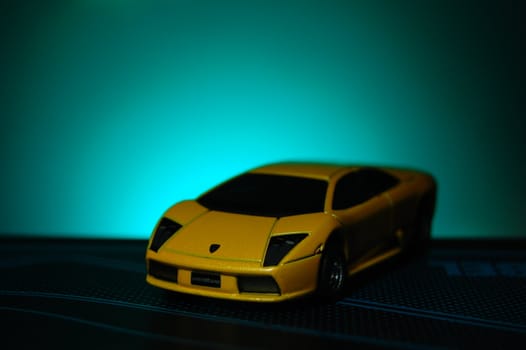 Scale model replica of lamborghini murciélago on blue sunburst background