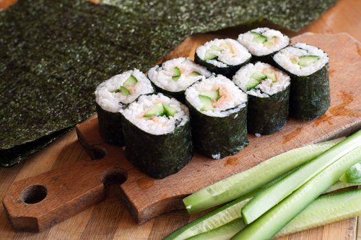 An image of california rolls on wooden plate