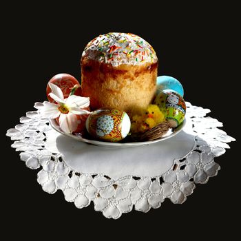 An image of an easter cake on a plate with eggs and flower