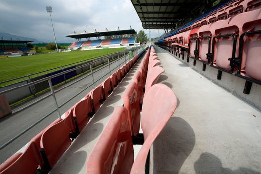 An image of a green field and chairs of stadium