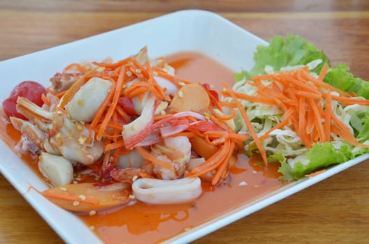 Thai style cuisine ,  spicy seafood salad on wooden table