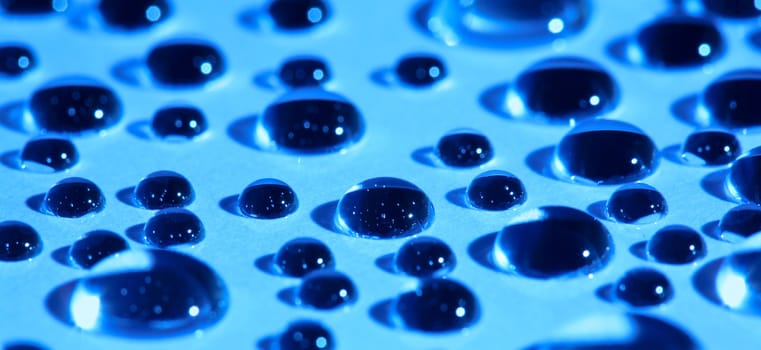 Abstract background with water drops on blue glass