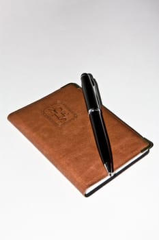 Notebook with pen on white backgruond.