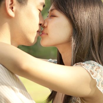 Young Asian couple kissing at outdoor