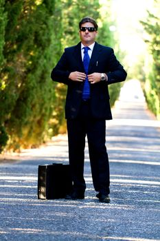 View of a young male business man on a asphalt road.
