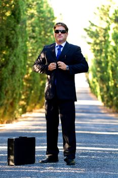 View of a young male business man on a asphalt road.