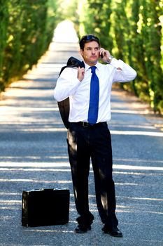View of a young male business man on a asphalt road.