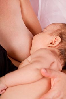 View of a newborn baby breast feeding.