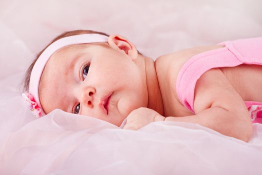 View of a newborn baby on smooth bed.