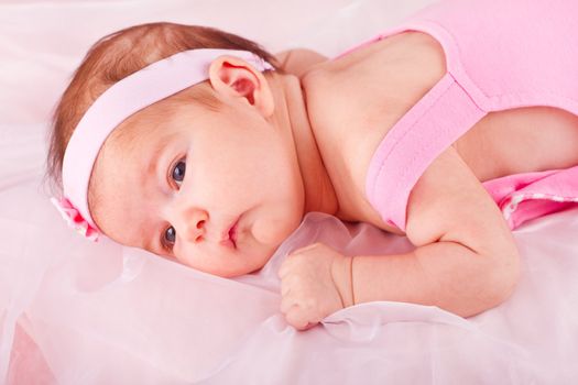View of a newborn baby on smooth bed.